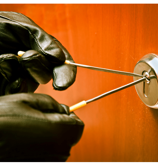 Hands in black gloves picking a lock on an office door