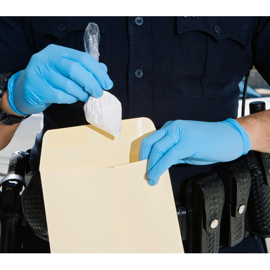 Police officer placing drugs in an envelope